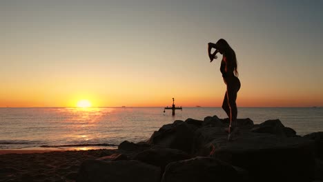 Stilvolle-Frau-Beim-Yoga-Taichi-Tanz-Am-Strand-Bei-Sonnenuntergang