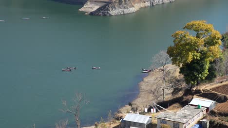 Una-Vista-De-ángulo-Alto-De-Algunos-Pequeños-Botes-De-Remo-En-El-Lago-Kulekhani-En-Nepal,-Llevando-A-Los-Turistas-A-Un-Recorrido-Por-El-Lago.