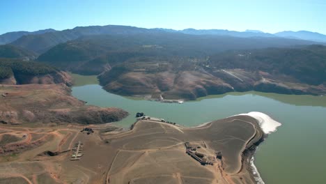 Dique-Del-Pantano-De-Sau-En-Cataluña,-España,-Intensa-Sequía-En-2024-Vuelo-De-Drones-Sobre-Tierras-Desérticas,-Lago-Seco-En-España