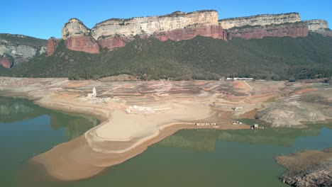 Sau-swamp-dike-in-Catalonia,-Spain,-intense-drought-in-2024-Drone-flight-over-desert-land,-dry-lake-in-Spain-pantano-de-sau