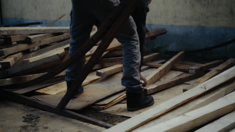 Worker-sorting-wood-on-construction-site
