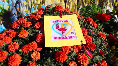 Calle-Khreshchatyk-Con-Flores-Rojas-Y-Banderas-Conmemorativas-Ucranianas-Con-Nombres-De-Soldados-Caídos-En-Kiev,-Ucrania,-Honor-A-Los-Soldados-Que-Murieron-Durante-La-Guerra-Entre-Rusia-Y-Ucrania,-Honrando-El-Recuerdo,-4k