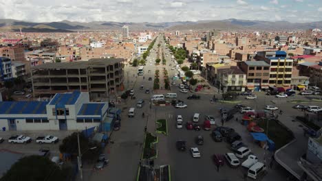 Flyover:-Chaotic-vehicle-traffic-on-wide-boulevard-in-Oruro,-Bolivia