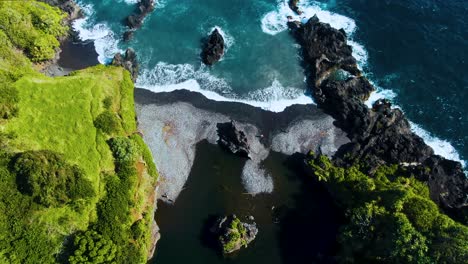 Volcanic-beach-and-iconic-Venus-Pool-in-Hawaii,-aerial-drone-view