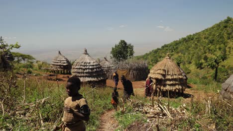 Una-Toma-Amplia-De-Una-Aldea-Tribal-En-Una-Montaña-Del-Este-De-África-Con-Chozas-Con-Techo-De-Paja