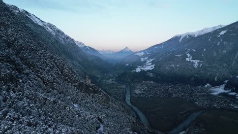 sunset-in-a-wintry-valley-in-the-mountains-and-a-small-ruin-at-the-edge-of-the-forest