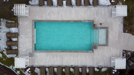 Una-Piscina-Climatizada-En-Un-Resort-De-Lujo-Alpino-Se-Vuelve-Más-Azul-Cuando-El-Dron-Despega-Hacia-Arriba