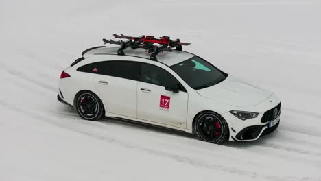 White-car-stops-on-snowy-race-tack-turn-with-hazard-lights-on,-drift-event