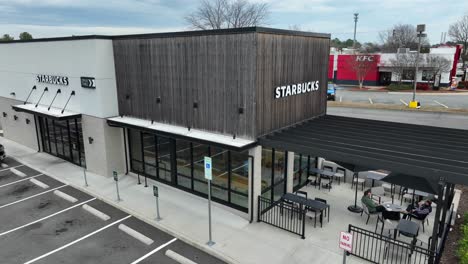 Resting-people-outdoors-on-table-of-Starbucks-Cafe-with-KFC-in-background