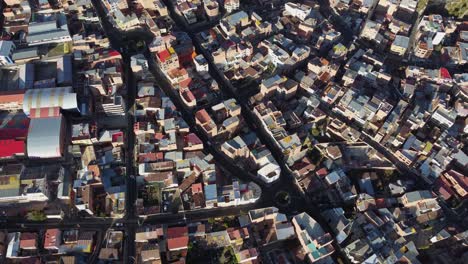Aerial-looks-down-onto-light-and-shadow,-streets-of-La-Paz,-Bolivia