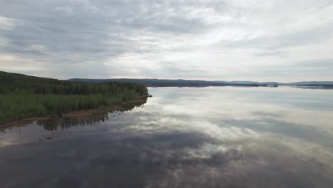 Toma-Aérea-Del-Lago-Sueco-Con-árboles-A-Un-Lado-Durante-El-Día-En-Suecia