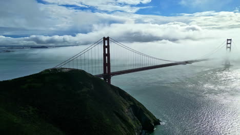 Aerial-drone-panning-view-of-Golden-Gate-Bridge-on-a-sunny-foggy-day