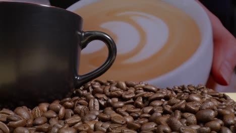 Makroobjektiv-Ansicht-Einer-Kaffeetasse,-Kaffeebohnen-Und-Einem-Hintergrundbild-Einer-Kaffeetasse-Mit-Kaffee-Und-Einem-Video,-Das-Hineingedrückt-Wird