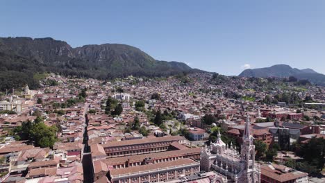 Aerial-view-backwards-over-the-Santuario-Nuestra-Señora-del-Carmen,-in-sunny-Bogota,-Colombia