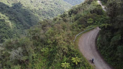 Aerial-tracks-bicycles-on-famous-Yungas-Rd,-Death-Road-in-Bolivia-mtns