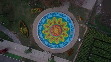 Colorful-round-floral-design-fountain-from-top-down-view-with-rotating-camera-with-garden-landscaping-for-Lunar-New-Year