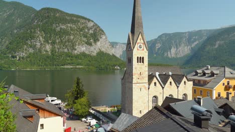 Hallstatt-Church-Overlooking-Lake-While-People-Walk-Around-It