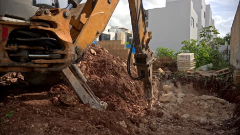 Zeitlupe-Eines-Baggerladers-Mit-Einem-Hydraulikhammer,-Der-Auf-Einer-Baustelle-Ein-Loch-Für-Einen-Pool-Bohrt