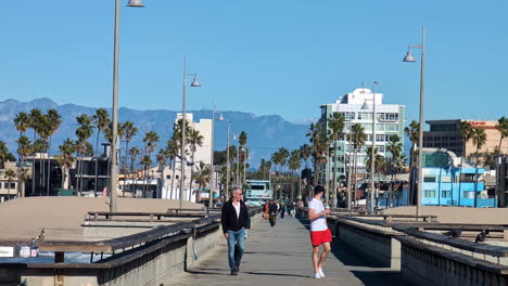 Venice-Beach-Pier-Gente-Caminando-California,-EE.UU.-Palmeras-Y-Edificios