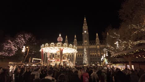 Carousel-during-night-the-Vienna-Christmas-Fare-at-Rathauspark,-across-the-City-Hall-of-Vienna,-Austria---December-16,-2023