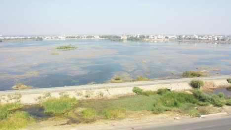 Aerial-drone-view-drone-camera-is-taking-place-where-a-big-lake-is-visible-and-many-bushes-are-visible-around