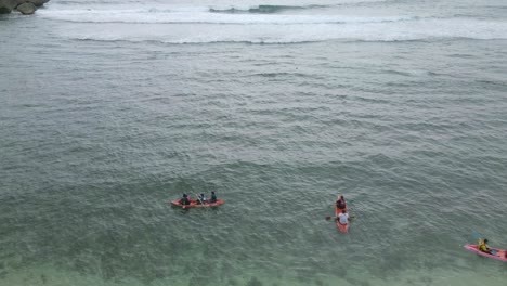 Drohnenaufnahme-Von-Menschen,-Die-Am-Strand-Kajak-Fahren