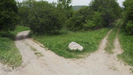 Zurückweichende-Drohnenaufnahme-Eines-Felsmarksteins-In-Der-Mitte-Einer-Kreuzung-In-Den-Wäldern-Des-Dorfes-Tsarichina-Hole-In-Bulgarien