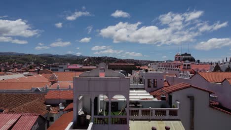 Aerial-camera-flies-out-through-window-over-rooftops-of-Sucre,-Bolivia
