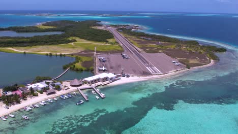 Luftaufnahme-Eines-Fischerdorfes-Mit-Kleinem-Flughafen,-Flugzeugen-Und-Start--Und-Landebahn,-Dolly-Out