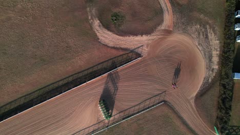 Jockeys-and-horses-on-racetrack,-overhead-aerial-shot,-rural-USA,-4K