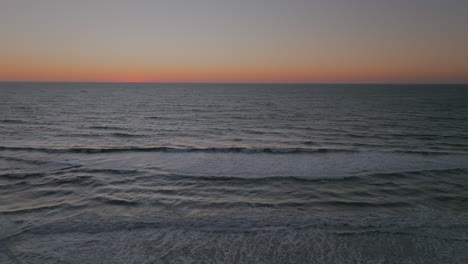 Establishing-Shot-of-tranquil-sunset-waves-with-a-orange-horizon