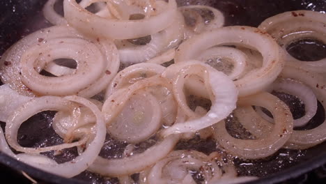 Closeup:-Onion-rings-sizzle,-sputter-as-they-fry-in-hot-frying-pan-oil