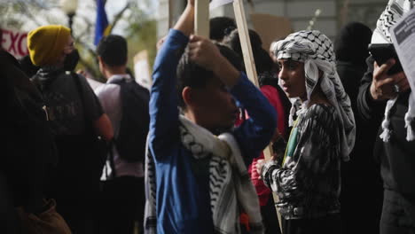 Un-Niño-Palestino-Con-Una-Keffiyeh-Sostiene-Un-Cartel-En-Una-Protesta-A-Favor-De-Palestina.