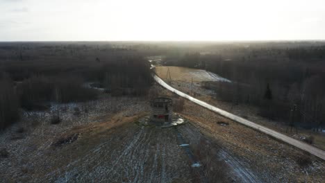 Aerial-view-of-old-abandoned-military-observation-tower,-bright-evening-sky