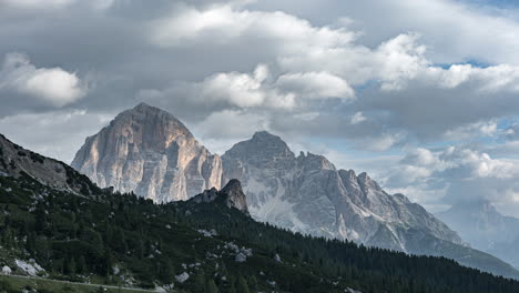 Grey-moody-clouds-flowing-above-massive-Dolomite-mountains,-time-lapse