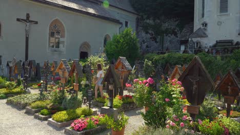 Lápidas-De-Madera-En-El-Cementerio-De-La-Iglesia-De-Hallstatt-Con-Turistas-Caminando