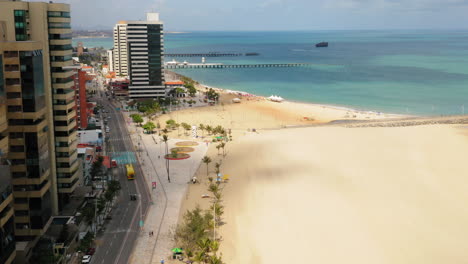 Aerial-view-of-the-buldings-in-front-of-the-sea,-the-avenue-and-the-empty-beach-in-a-cloudy-day,-Fortaleza,-Ceara,-Brazil