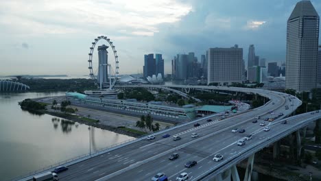 Drone-shot-flying-above-ECP-Bridge-towards-Marina-Promenade-and-Singapore-Flyer-Eye,-tracking-of-Formula-1-One-Paddock-Area