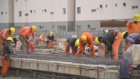 Trabajadores-De-La-Construcción-Con-Equipo-De-Alta-Visibilidad-Trabajando-En-El-Sitio,-Durante-El-Día