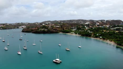 Yachts-moored-in-peaceful-pickly-bay-marina,-grenada,-with-lush-hills-in-the-background,-aerial-view
