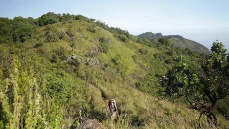 Un-Hombre-Occidental-Caminando-A-Lo-Largo-De-La-Línea-De-Una-Montaña-En-El-Este-De-África-Con-Increíbles-Vistas-Tropicales