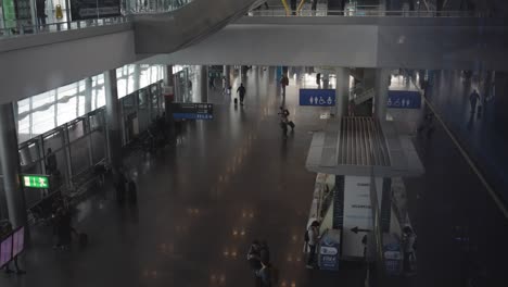 Timelapse-Aéreo-Mirando-Hacia-Abajo-En-Un-Pasillo-Concurrido-En-El-Aeropuerto-De-Dublín,-Mientras-Los-Viajeros-Recorren-El-Edificio-De-La-Terminal-Durante-Su-Tránsito.