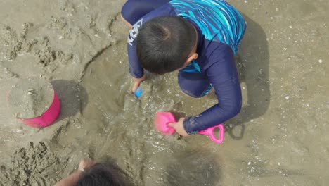 Zwei-Asiatische-Kinder-Spielen-Im-Sand-An-Einem-Wunderschönen-Strand