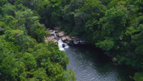 Una-Serena-Cascada-En-La-Exuberante-Selva-De-Oxapampa,-Perú,-Con-Una-Tranquila-Piscina-Debajo,-Vista-Aérea