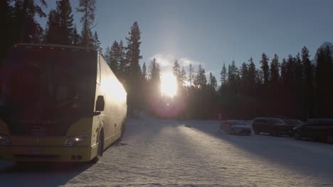 Passenger-bus-on-snowy-parking-lot-sun-backlit