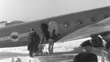 In-Den-1930er-Jahren-Halfen-Mitarbeiter-Einer-Fluggesellschaft-Den-Passagieren-Beim-Einsteigen-In-Ein-Oldtimer-Flugzeug