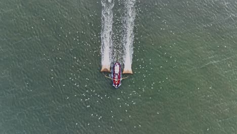 Drohnenaufnahme-Von-Oben-Eines-Fischerboots,-Das-Die-Netze-Durch-Das-Wasser-Zieht