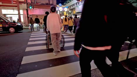 Pedestrians-of-all-types-confidently-cross-the-street-at-a-typical-traffic-stop-in-Tokyo,-Japan