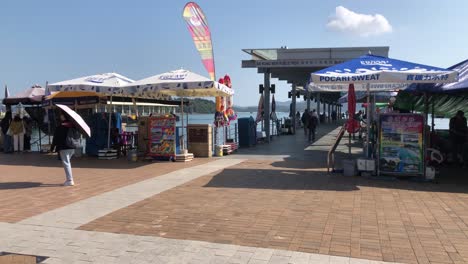 People-walk-along-the-water-front-in-Sai-Kung,-Hong-Kong