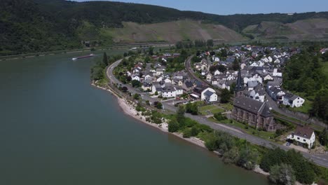 Ships-passing-riverside-german-village-at-Great-Rhine-loop-of-Boppard,-Aerial